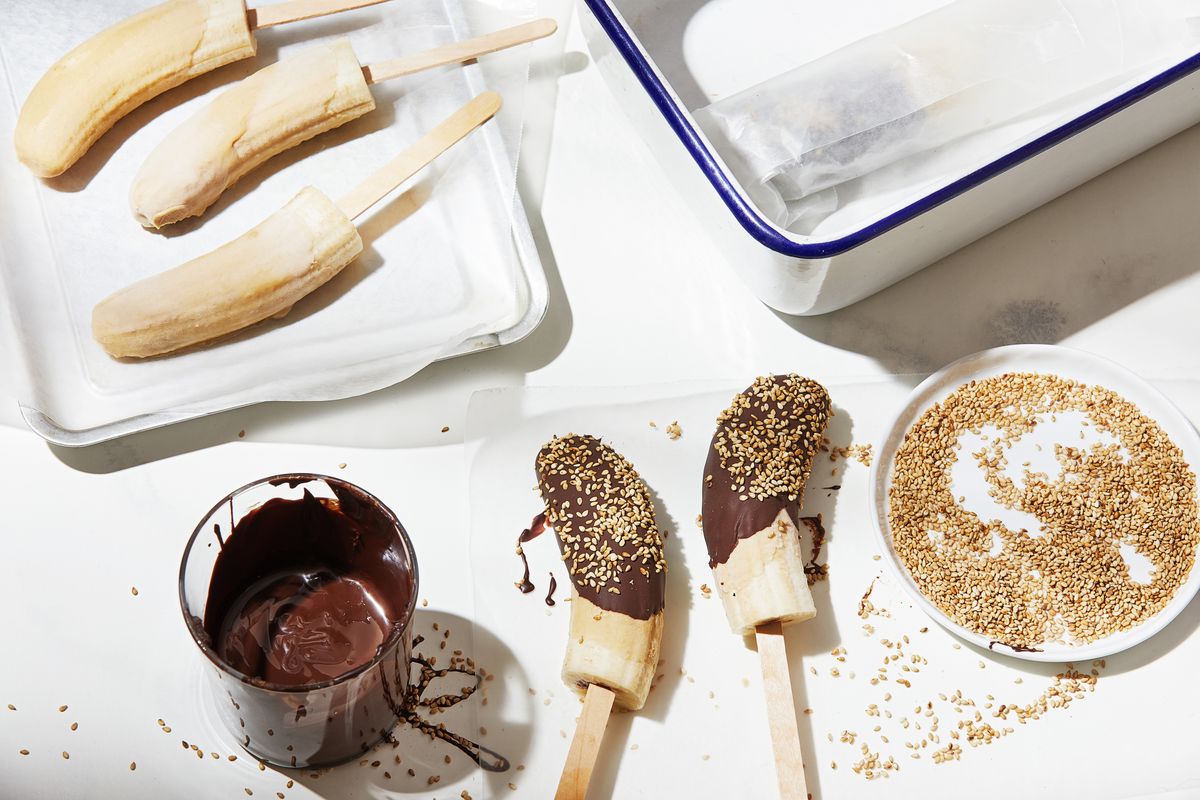 A dip in honey-sweetened tahini and a sprinkle of toasted sesame seeds add an unexpected rich, creamy layer and exciting nutty flavor to the familiar, healthful treat frozen bananas.  (Tom McCorkle/For the Washington Post)