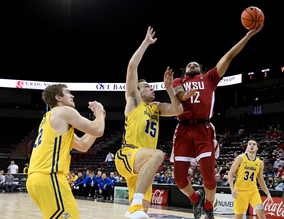 Washington State guard Michael Flowers (12) heads to the basket as South Dakota State guard Noah Freidel (15) defends during a NCAA college basketball game, Saturday, Dec. 11, 2021, in the Spokane Arena.  (COLIN MULVANY/THE SPOKESMAN-REVIEW)