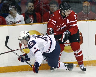 Team Canada’s Alex Pietrangelo dumps Tyler Johnson of the United States during the first period of Tuesday’s championship game.  (Associated Press)