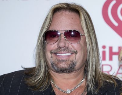 In this Sept. 19, 2014 photo, Vince Neil of Motley Crue, arrives at the iHeart Radio Music Festival in Las Vegas. Neil has broken ribs during a fall off the stage at a concert in Tennessee. In video footage from the performance Friday, Oct. 15, 2021, Neil can be seen clapping at the edge of the stage with his guitar strapped around him before his fall.  (Andrew Estey)