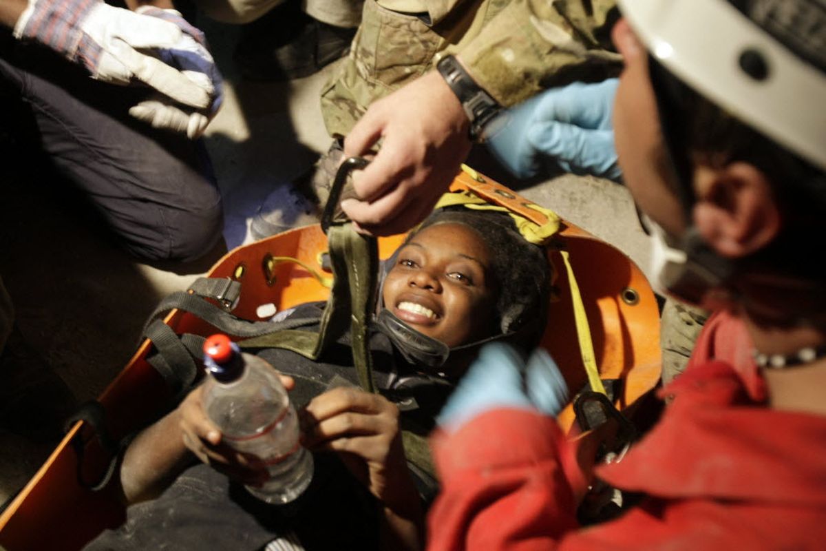 Earthquake survivor Hotteline Lozama, 26, smiles as she was pulled out from the rubble by French aid group Secouristes Sans Frontieres in Port-au-Prince, Haiti, Tuesday, Jan. 19, 2010. International working groups are racing against the clock across Haiti to find more victims still possibly buried alive in the rubbles.  (Associated Press)