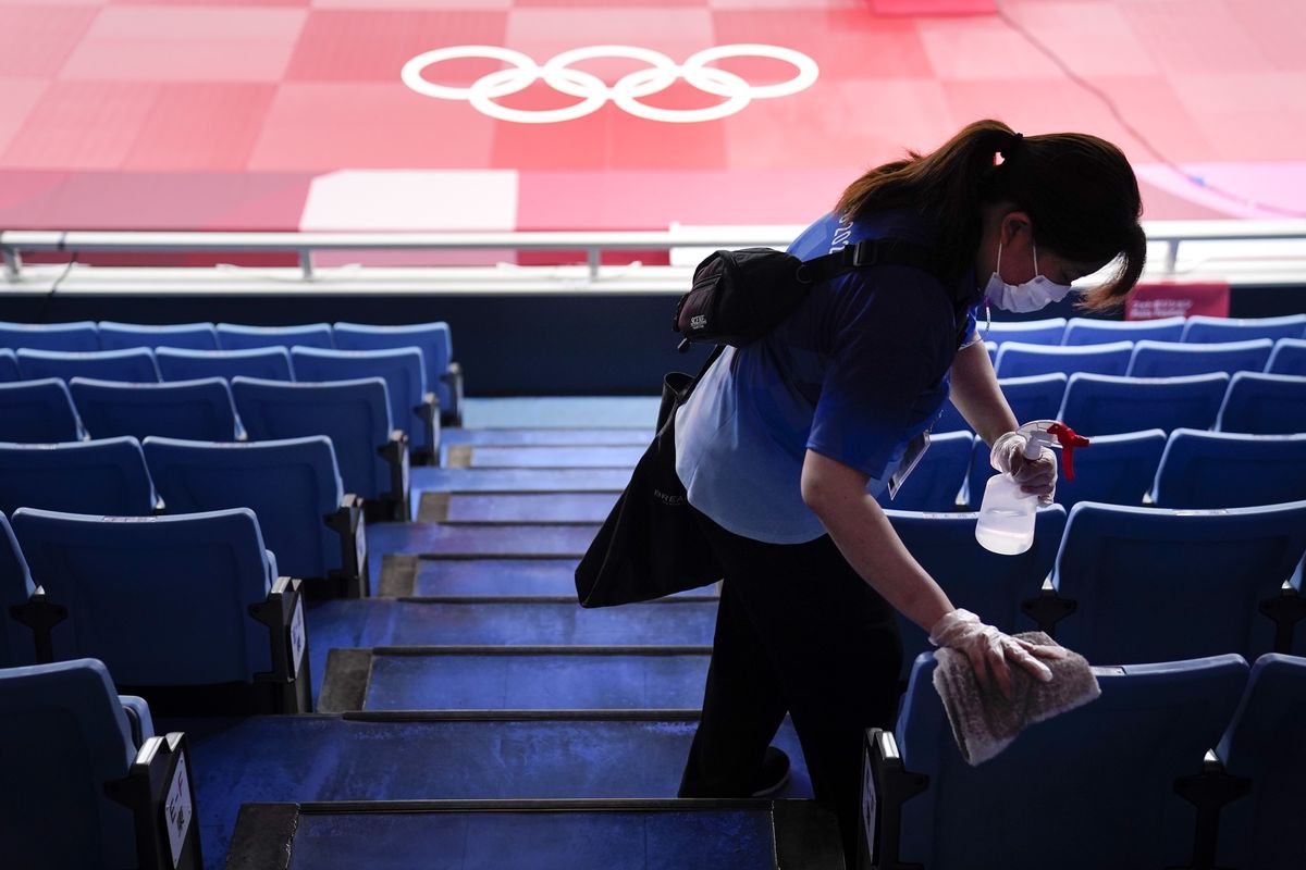 A worker disinfects the seats before judo matches at the Summer Olympics on July 24, 2021, in Tokyo, Japan.  (Jae C. Hong)
