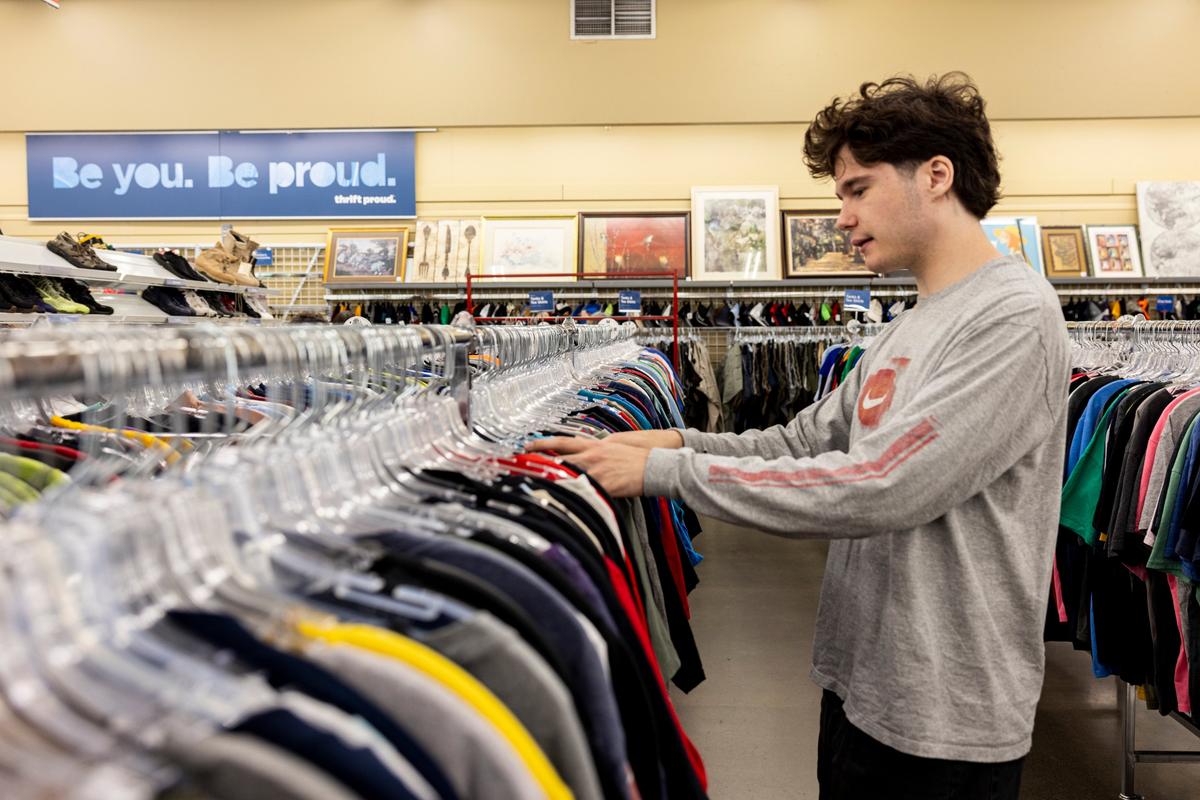 Quinn Brown looks through men’s shirts on Tuesday at Value Village in Tigard, Ore. 