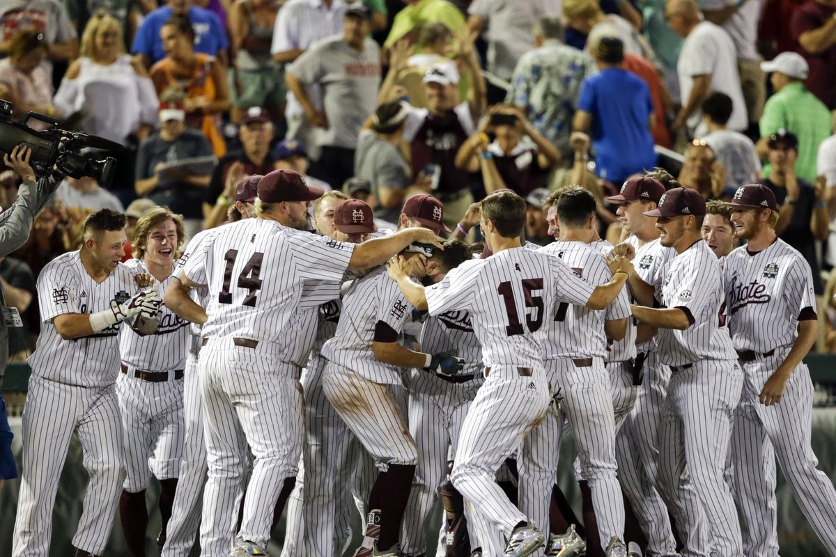 Mississippi State players mob Luke Alexander, center, who hit a single that scored the winning run by Hunter Stovall against Washington in the ninth inning of an NCAA College World Series baseball game in Omaha, Neb., Saturday, June 16, 2018. (Nati Harnik / AP)