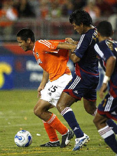 
Chivas USA defenders grab Houston's Brian Ching, left. 
 (Associated Press / The Spokesman-Review)