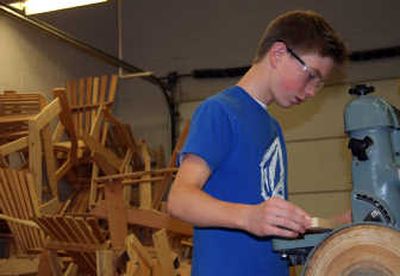
Freshman John Thompson works in the Post Falls High wood shop on Monday with a stack of items created for the annual wood shop auction in the background. 
 (Taryn Hecker / The Spokesman-Review)