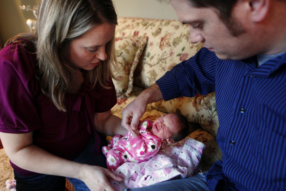 From left, Kathy Luaces unwraps a blanket from her newborn baby girl, Avery, with the assistance of her husband and Avery’s father, Dave Luaces, at their home in January. Avery was born six weeks early and weighed 4 pounds, 6 ounces. McClatchy-Tribune photos (McClatchy-Tribune photos)