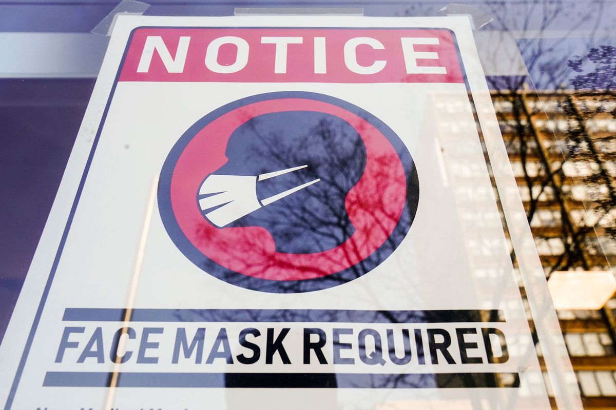 A sign requiring masks as a precaution against the spread of the coronavirus is posted on a store front in Philadelphia on Feb. 16.  (Matt Rourke)