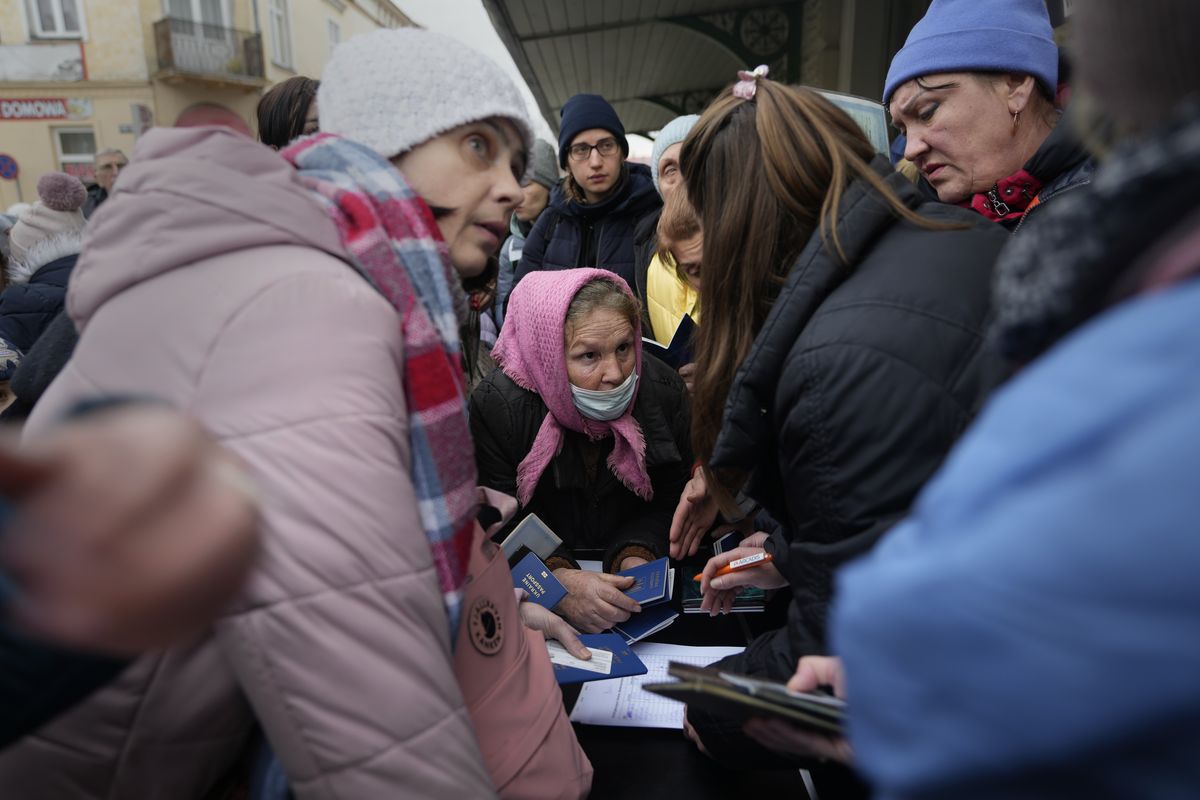 People, fleeing Ukraine, register for a bus which will take them to Germany, at the train station in Przemysl, Poland, Thursday, March 3, 2022. More than 1 million people have fled Ukraine following Russia