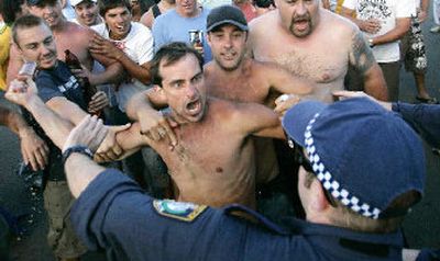 
A man tries to hit police with a beer bottle at Cronulla Beach in Sydney on Sunday after ethnic tensions erupted into running battles between police and a mob of thousands of youths, many chanting racial slurs. 
 (Associated Press / The Spokesman-Review)