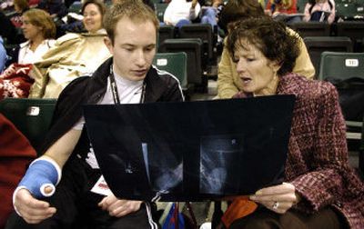 
Chris Anders looks at an X-ray of his broken thumb with Teresa Budvarson, the mother of his pairs partner, Kalie.
 (Colin Mulvany / The Spokesman-Review)