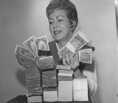 Bank teller Mrs. Joe Melton holding amount of money that the average San Fernando Valley, Calif., family made in 1963. Intuit acquired personal finance app Mint in 2009. This week the company announced it plans to shut down Mint on Jan. 1.  (Los Angeles Times)