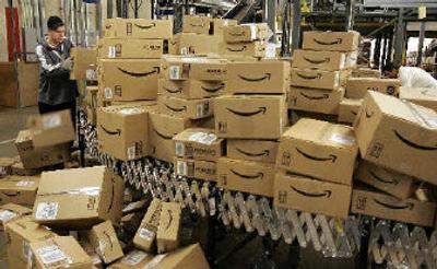 
An Amazon.com worker moves boxes with merchandise for shipment.  
 (Associated Press / The Spokesman-Review)
