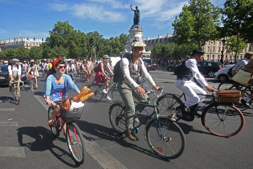 Parisians wearing vintage fashions, ride vintage bicycles as they leave the Rebublique square for a ride toward the Bois de Vincennes, in Paris, Sunday June 7, 2015. Hundreds of Parisians in black berets are riding vintage balloon-tired bicycles with baskets full of crusty baguettes on a retro-inspired outing. Sunday's ride is the culmination of the weekend Bicycle Festival taking place across France. (AP Photo/Remy de la Mauviniere)