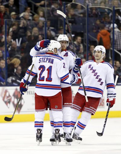 Derek Stepan is congratulated by teammates Marc Staal, center, and Dan Girardi after a goal in a playoff clinching win. (Jay LaPrete / Associated Press)