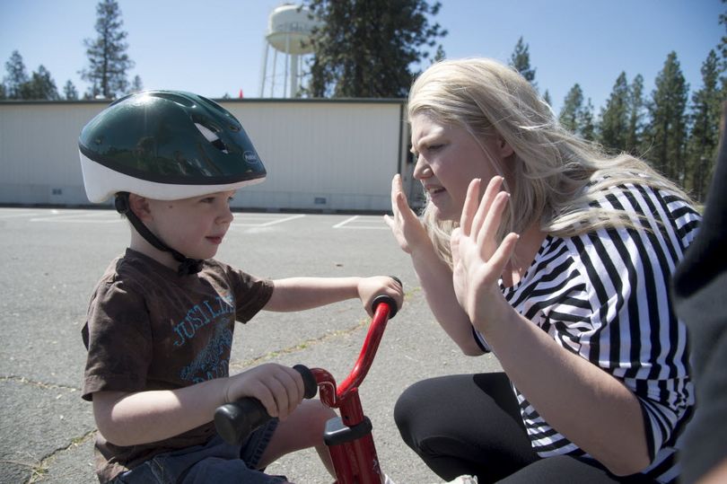 Windsor Elementary preschool teacher Jennifer Gonzalez asks Bobby Enright if he's finished riding the trike during recess. (Jesse Tinsley)