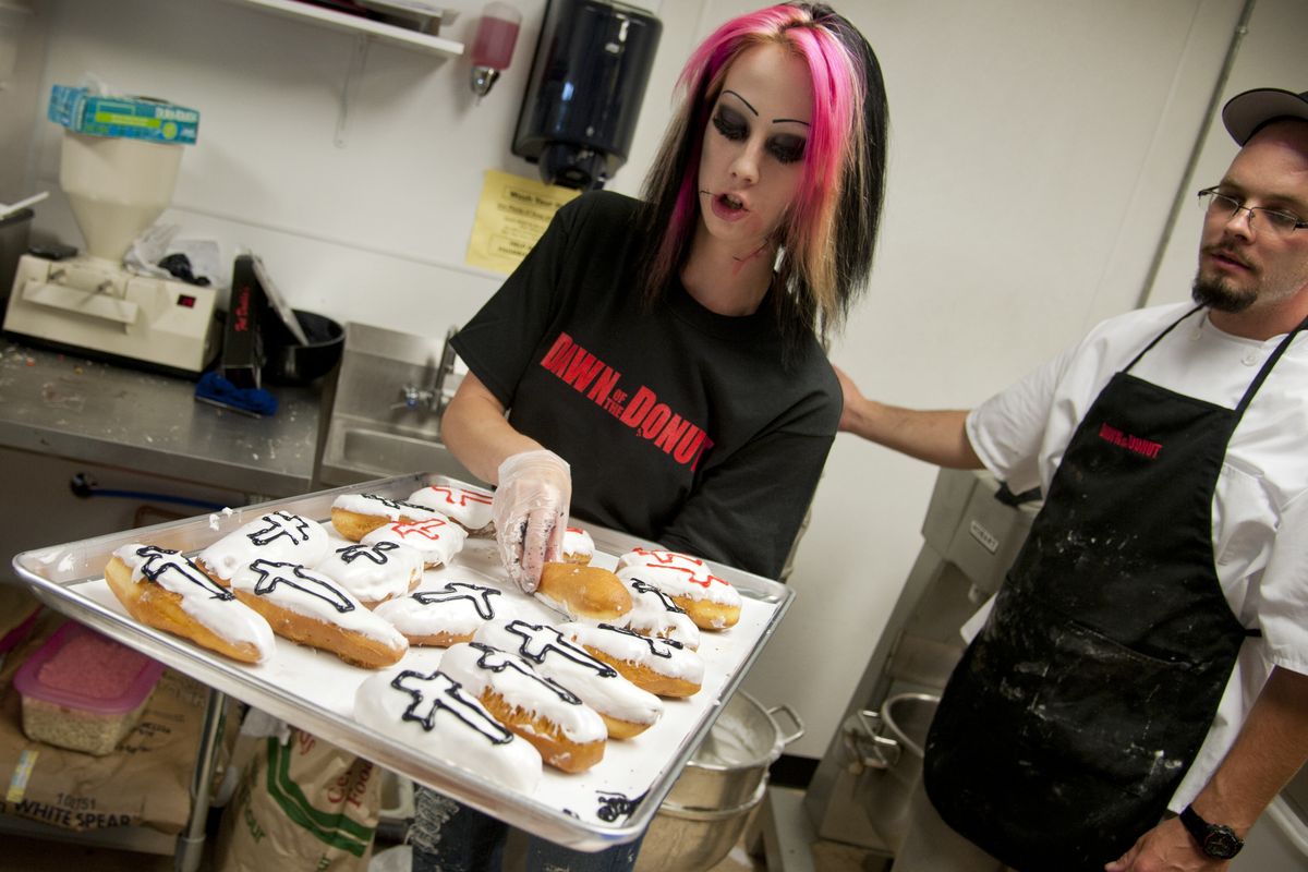 Jayy De Boer, Dawn of the Donut manager, and Jeremy Marlow, right, finish a tray of coffin-shaped doughnuts. (Dan Pelle)