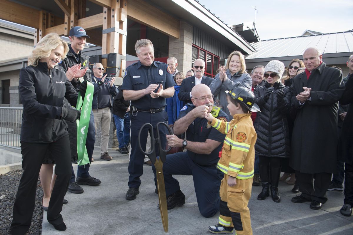 Firefighter Paul Hammersley, kneeling, bumps knuckles with four-year-old Mark Frazier after the ribbon cutting at the new Spokane Valley station on Country Vista Drive in Liberty Lake, Monday, Dec. 4, 2017. Mark isn’t related to any Spokane Valley firemen, but he loves getting dressed up in his firefighter costume and attending events like this. (Jesse Tinsley / The Spokesman-Review)