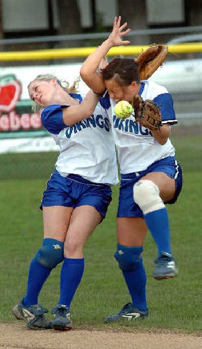 
CdA's Jessyca Le, right, bobbles the ball after backing into center fielder Jackie Lenz. 
 (Jesse Tinsley / The Spokesman-Review)