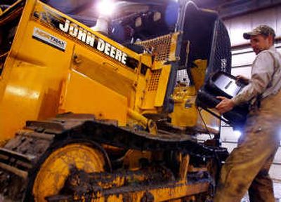 
A heavy equipment mechanic works on a John Deere bulldozer at Martin Equipment in Springfield, Ill. Deere & Co. reported a 52 percent increase in fourth-quarter earnings Wednesday.Associated Press
 (FILE Associated Press / The Spokesman-Review)