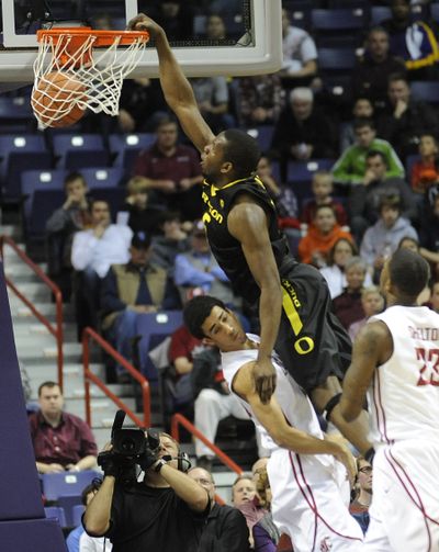 Dexter Kernich-Drew of WSU, below, tries to take the charge as Oregon's Olu Ashaolu dunks during second half action  in the Spokane Arena on Thursday. (Christopher Anderson / The Spokesman-Review)