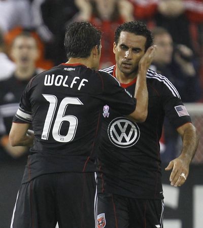 Josh Wolff congratulates Dwayne De Rosario on his goal against Portland. (Associated Press)
