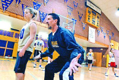 
Coach Steve Bourgard demonstrates the proper defensive position to Bridgett Lund and the Kellogg girls basketball team. 
 (Jesse Tinsley / The Spokesman-Review)
