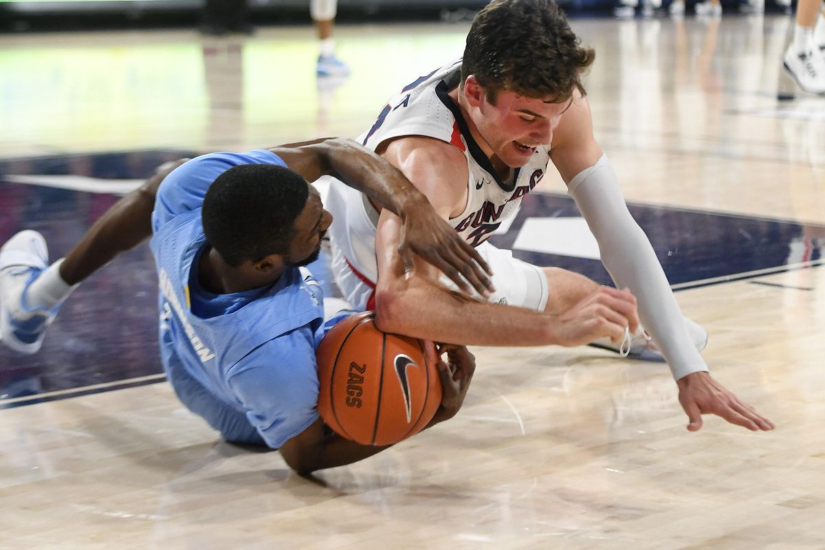 North Carolina guard Brandon Robinson (4) and Gonzaga forward Corey Kispert (24) fall chasing a loose ball during the first half of a college basketball game, Wed., Dec. 18, 2019, at the McCarthey Athletic Center. (Colin Mulvany / The Spokesman-Review)