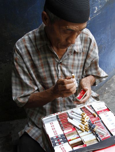 A cigarette vendor packs cigarettes to be sold individually for one US cent per stick in Jakarta, Indonesia, Tuesday, Sept. 11, 2012. Indonesian men rank as the world�s top smokers, with two out of three of them lighting up in a country where cigarettes cost pennies and tobacco advertising is everywhere. (Achmad Ibrahim / Associated Press)