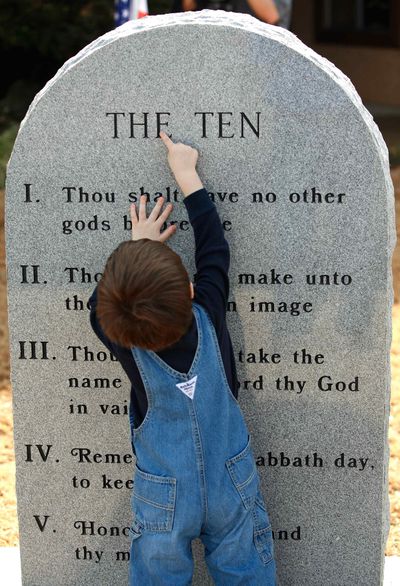 Nate Shepherd, 2, uses his finger to trace chiseled letters on the monument after a ceremony in Poteau, Okla., Wednesday, Jan. 20, 2010. Shepherd is grandson of former Poteau Mayor Don Barnes, who started the effort to place the Ten Commandments marker in the town. About 200 people attended the unveiling and dedication of a new monument with the Ten Commandments etched into its granite surface on the front lawn of the Community State Bank. (Jim Beckel / The Oklahoman)