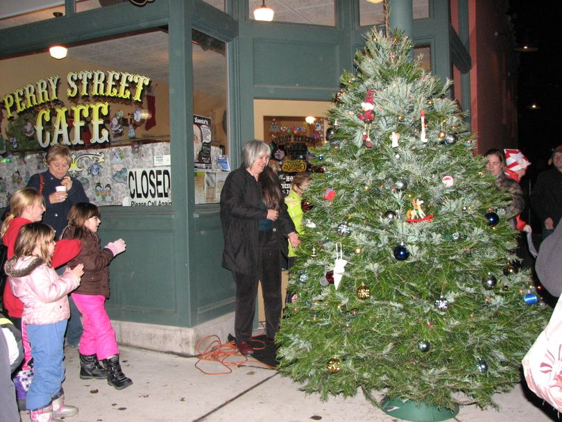 Pastor Debra Conklin plugs in the Christmas tree outside the Perry Street Cafe on Tuesday Dec. 14, 2010 (Pia Hallenberg)