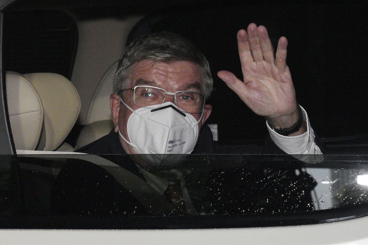 International Olympic Committee (IOC) President Thomas Bach waves from the vehicle to media upon his arrival an accommodation Thursday, July 8, 2021, in Tokyo. Bach arrived on Thursday, July 8, 2021, in Tokyo as Japan Prime Minister Yoshihde Suga was set to declare a state of emergency that is likely to result in a ban on fans from the Tokyo Olympics as coronavirus infections spread across the capital. (Eugene Hoshiko)