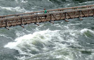 
The Spokane River roils under the swinging bridge as a hiker crosses at Riverside State Park on Wednesday. Many are casting a wary eye on water levels in the region.
 (Jesse Tinsley / The Spokesman-Review)