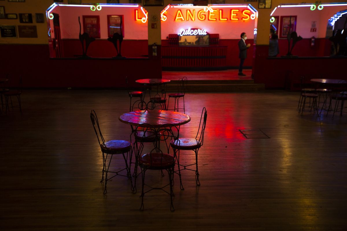 Tables and chairs sit the empty Salon Los Angeles during an event to raise money and keep open the iconic dance hall known as “The Cathedral of Mambo” amid the new coronavirus pandemic in Mexico City, Saturday, Sept. 5, 2020. Millionaires, writers, ambassadors, and movie stars danced here; now, shuttered for more than five months due to the pandemic, the owners of the fabled hall say they are in debt and may have to close and demolish it.  (Fernando Llano)