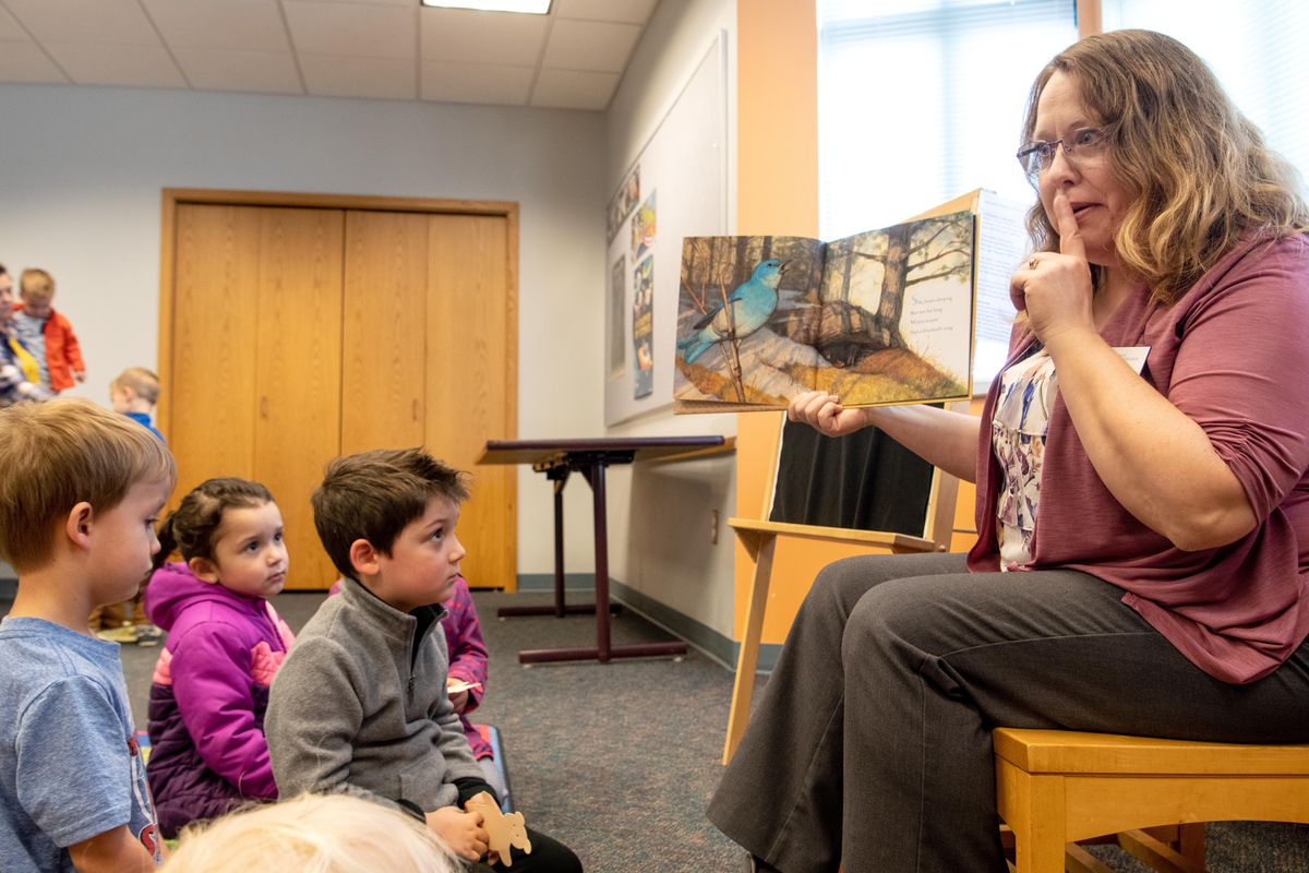 Spokane Public Library Youth Services Librarian Cathy Bakken, right, reads a story about hibernating animals Friday, Nov. 8, 2019 at Indian Trail Library during preschool story time. Local libraries are promotiong 1,000 Books Before Kindergarten, a program to help parents encourage kids to read or listen to books every day. (Jesse Tinsley / The Spokesman-Review)