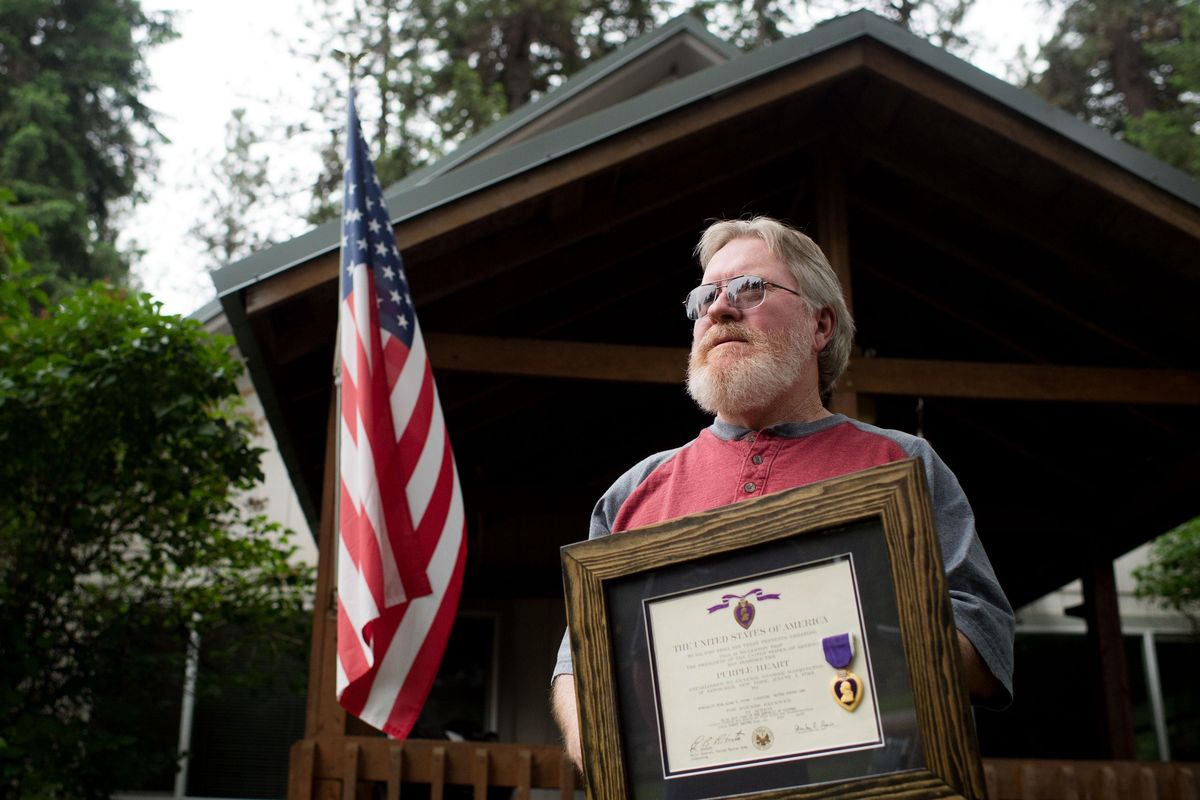 Vietnam veteran Allen Pough poses for a photo with his purple heart that he had thought long lost until high school friends reunited him with it on Wednesday, June 7, 2017, at his home in Newport, Wash. (Tyler Tjomsland / The Spokesman-Review)