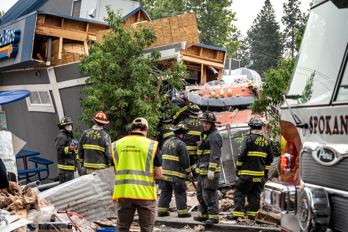 Two people were taken to a hospital Friday after a dump truck slammed into a Dutch Brothers coffee drive-thru and another business at Fourth Avenue and Freya Street, Friday, August 20, 2021.  (COLIN MULVANY/THE SPOKESMAN-REVIEW)