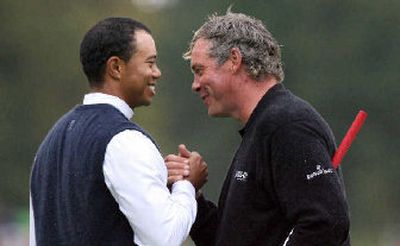 
Tiger Woods, left, shakes hands with Northern Ireland's Darren Clarke at the end of the second round Friday. 
 (Associated Press / The Spokesman-Review)