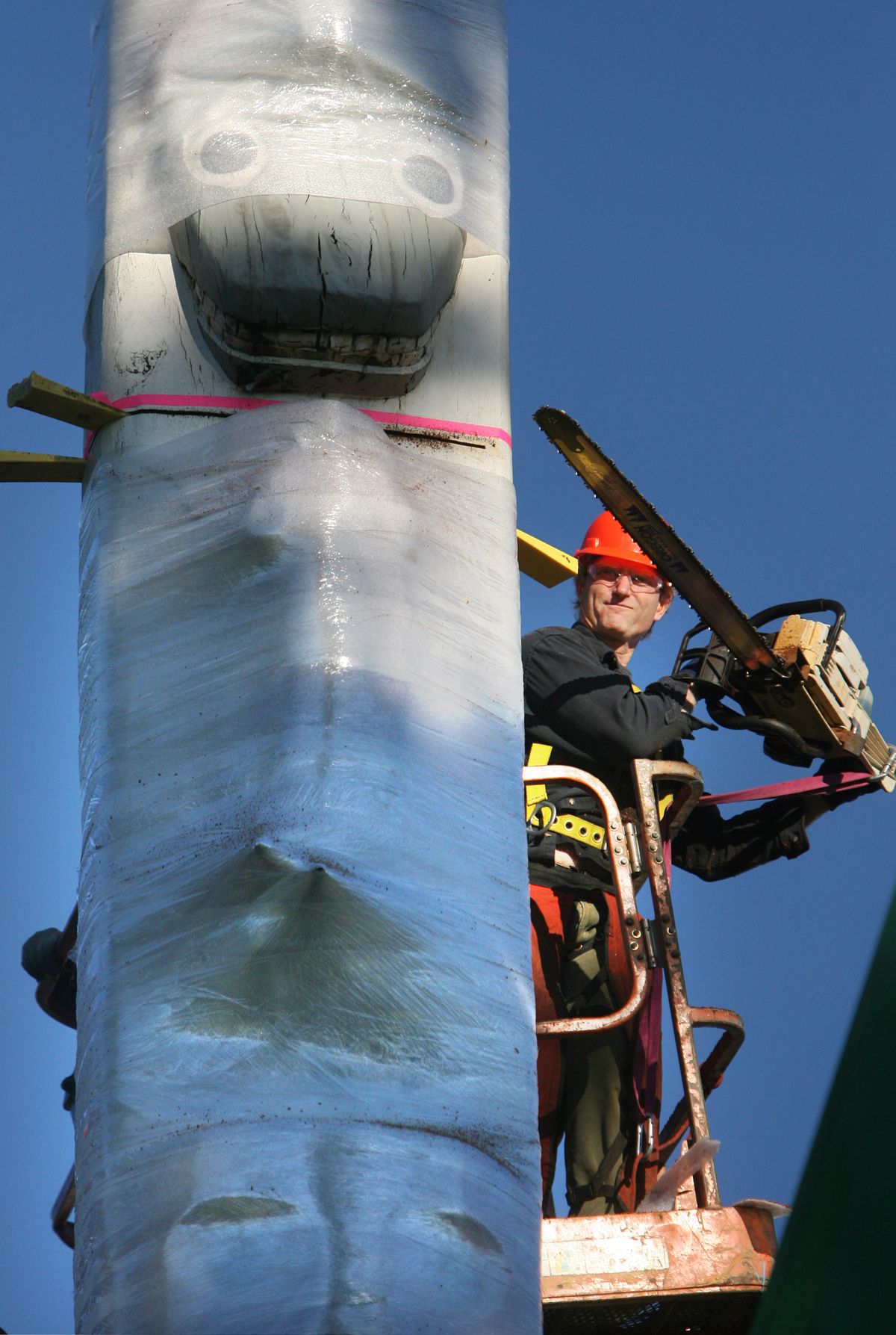  Mike Andersen, of Fabrication Specialties in Seattle, prepares to make a chain saw cut as crews remove the 71-foot-tall cedar Native American story pole on the Capitol Campus in Olympia on Wednesday. Rotting wood on the pole had created a safety hazard promoting its removal.  (Associated Press)