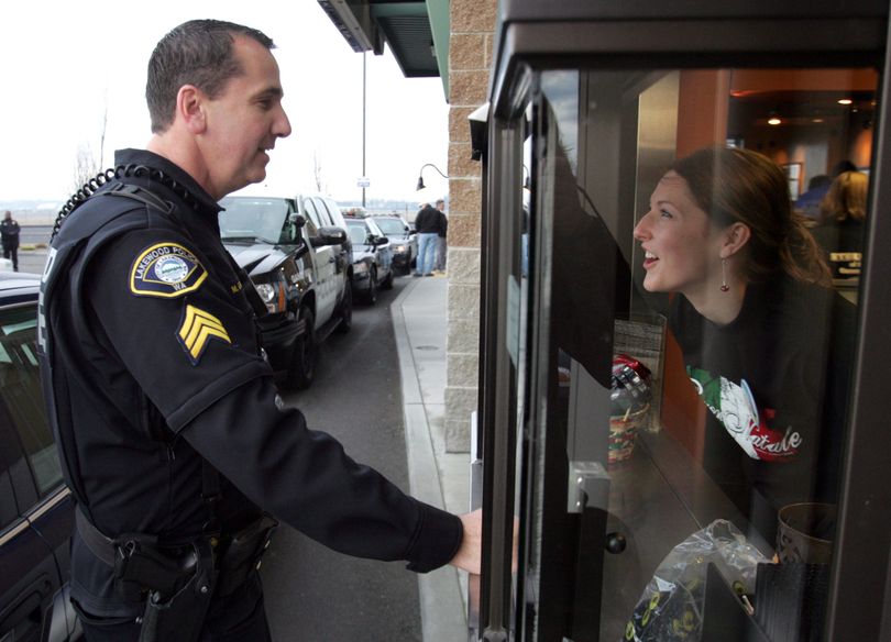 Lakewood police officer Mark Eakes is the first to place an order at the Forza Coffee Company drive thru in Parkland, Wash., which reopened  at 8:14 a.m. Saturday morning, Dec. 12, 2009, 13 days after four Lakewood police officers were fatally shot.  A bagpiper played as the Forza Coffee shop opened its doors at 8:14 a.m., the time on Nov. 29 when Maurice Clemmons ambushed Lakewood Police Sgt. Mark Renninger and Officers Ronald Owens, Tina Griswold and Greg Richards. (Janet Jensen / The News Tribune)