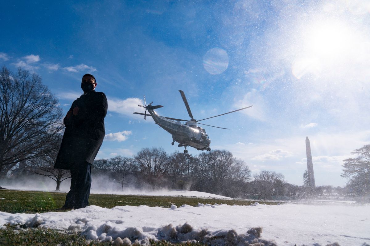 A U.S. Secret Service Special Agent stands as Marine One, with President Joe Biden aboard, lifts off from the South Lawn of the White House blowing snow with the rotor wash, Friday, Jan. 7, 2022, in Washington. Biden is en route to Colorado and Las Vegas.  (Alex Brandon)