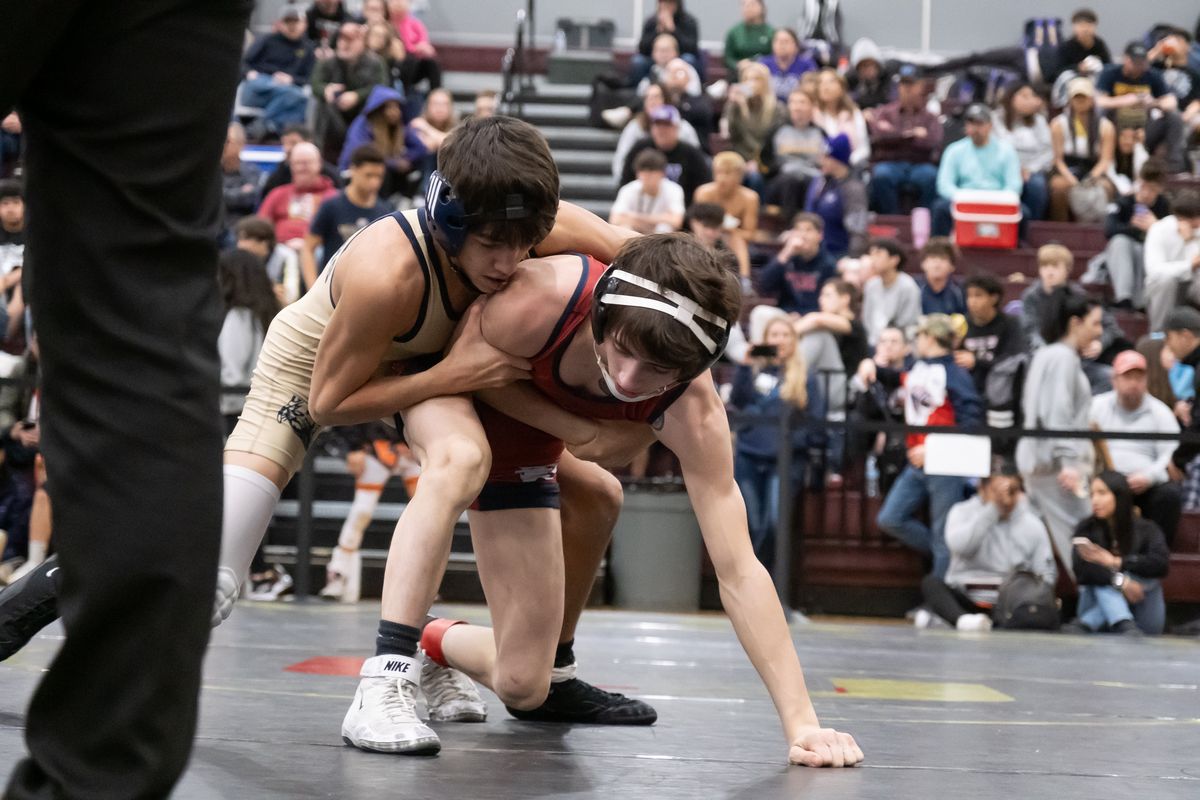Mead’s Kaysic Lundquist, left, takes down Mt. Spokane’s Tanner Crosby during the Region 4 State 3A-qualifying tournament Saturday at University High School.  (Madison McCord/For The Spokesman-Review)