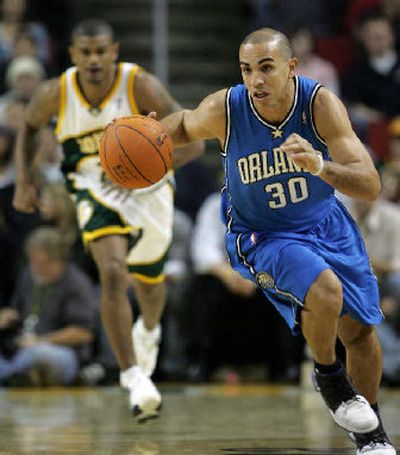 
Orlando's Carlos Arroyo races down the court as Seattle's Earl Watson looks on. 
 (Associated Press / The Spokesman-Review)