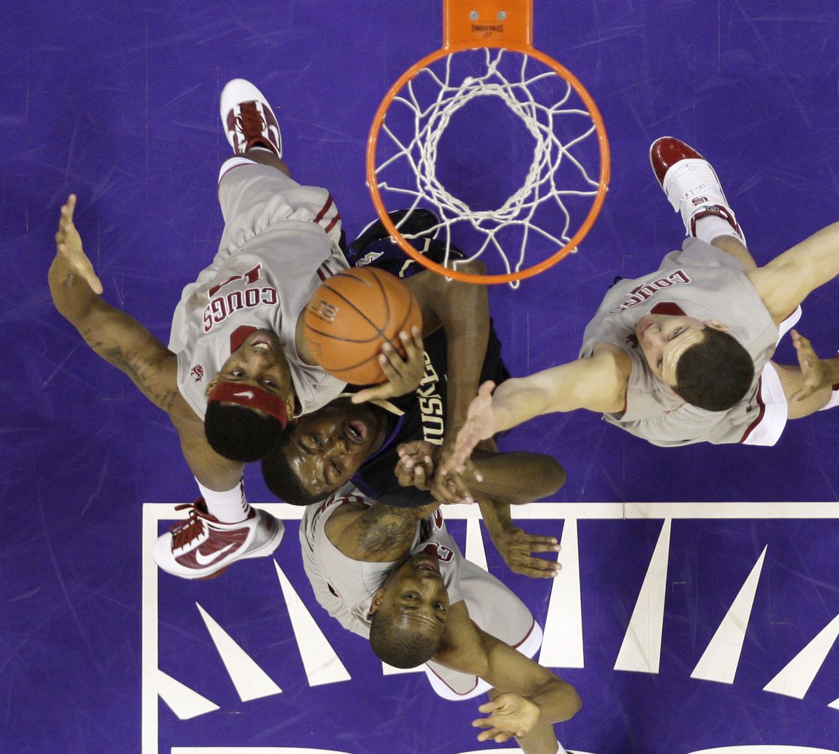 Washington’s Matthew Bryan-Amaning, center, battles for the ball with Washington State’s James Watson, left, Nik Koprivica, right, and Marcus Capers. (Associated Press)