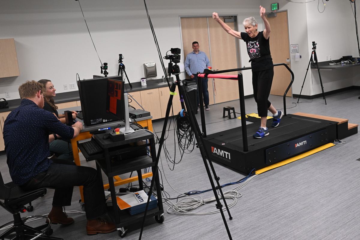 Hope Rolland, center, a volunteer participant in Gonzaga and the University of Washington School of Medicine’s research into Parkinson’s disease, reacts Thursday as she speed-walks through exercises on a specialized, instrumented split-belt treadmill while being monitored by seven motion-capture cameras run by GU Human Physiology majors Grace Fink, seated smiling, and Garrett Urvater, also seated.  (Tyler Tjomsland/The Spokesman-Review)