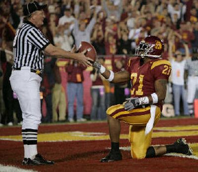 
USC's LenDale White hands the ball to an official after scoring a touchdown. 
 (Associated Press / The Spokesman-Review)
