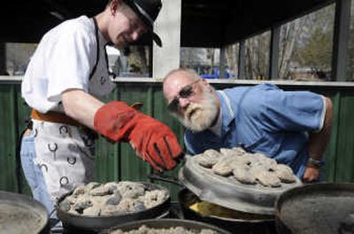 
Matt Conner, left, and his dad, Sam, of Athol, Idaho, peek at their cornbread creation in one of the Dutch ovens they were using at a Dutch oven cookery class earlier this month in Rathdrum, Idaho.  Cooking is accomplished by mounding charcoal under and on top of the cast iron pots. 
 (Photos by Jesse Tinsley / The Spokesman-Review)