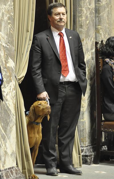 OLYMPIA – Sen. Mark Schoesler, R-Ritzville, with his dog Colt in the entry to the Senate floor, waits to vote yes on a bill defining what can be called a service animal. (Jim Camden / The Spokesman-Review)