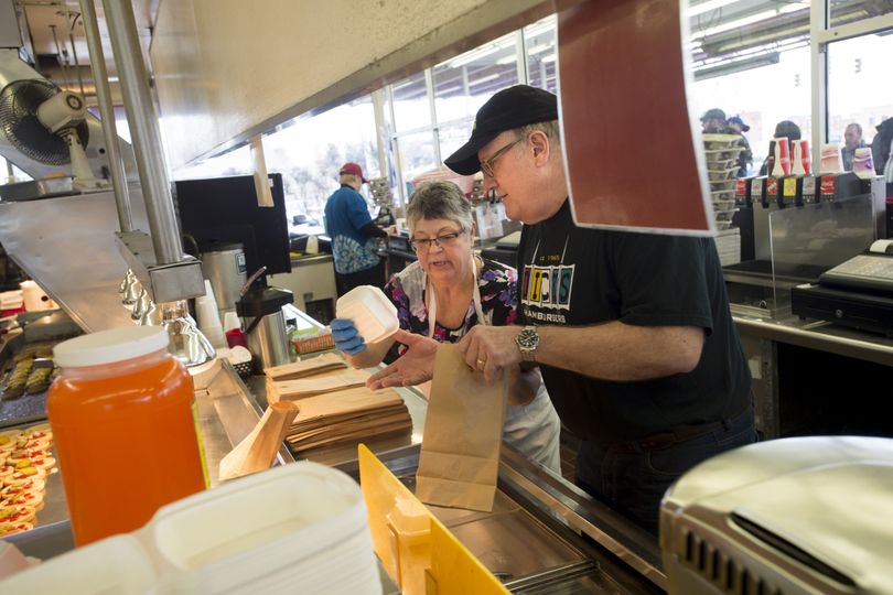 Writer Doug Clark gets pointers on the finer techniques of bagging Dick’s Hamburgers from Jackie Nelson at Dick’s Hamburgers in Spokane last week. (Tyler Tjomsland)