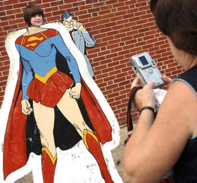 
Hannah Andrews, 4, of Greenwood, Ind., climbs atop a wooden cutout of Supergirl and smiles as her grandmother, Beulah Andrews, takes her picture just outside the Metropolis Super Museum in Metropolis, Ill., during the 28th annual Superman Celebration. 
 (Associated Press / The Spokesman-Review)